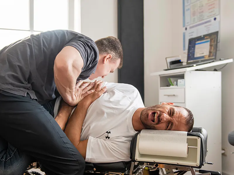 Chiropraktische Behandlung eines Boxers in Seitenlage auf einer Behandlungsliege