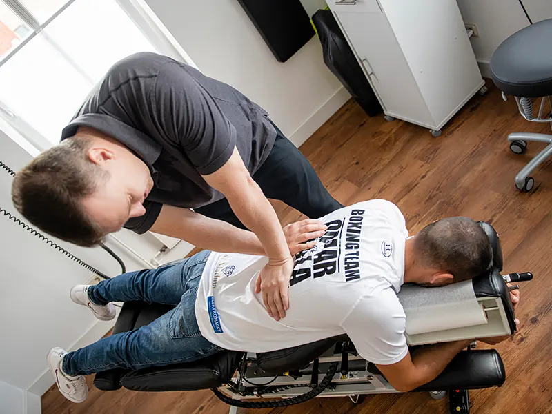 Chiropraktische Behandlung eines Boxers in Bauchlage auf einer Behandlungsliege