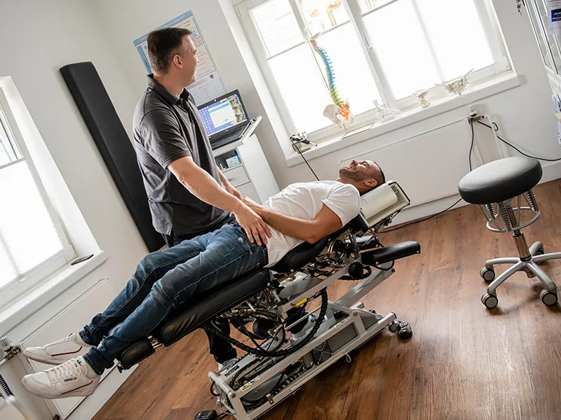Vorbereitung eines Boxers auf eine chiropraktische Behandlung auf der Behandlungsliege